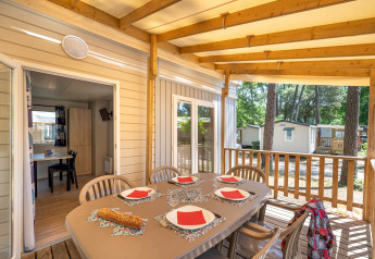 Zona pranzo sulla veranda del Stacaravan Confort, Flower Camping Au Bois Des Biches, Francia, apparecchiata.