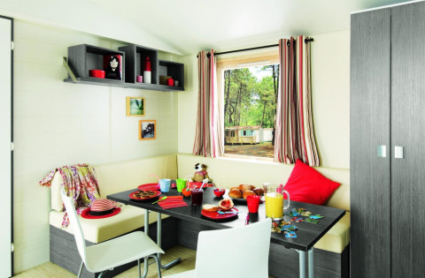 Eethoek van Stacaravan Confort op Flower Camping Au Bois Des Biches, Frankrijk, sfeervol voor ontbijt.