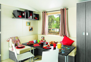 Eethoek van Stacaravan Confort op Flower Camping Au Bois Des Biches, Frankrijk, sfeervol voor ontbijt.