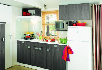 Cucina moderna in uno chalet Stacaravan Confort al Flower Camping Au Bois Des Biches, Francia, con mobili grigi.