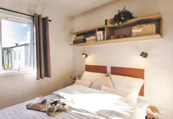 Knusse slaapkamer van Stacaravan Confort PLUS bij Flower Camping Au Bois Des Biches in Frankrijk, modern ingericht.