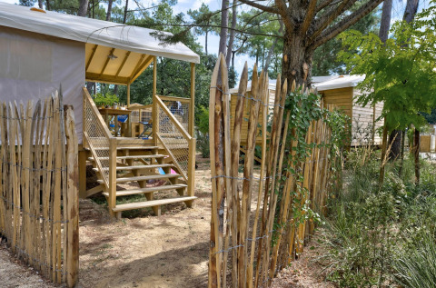 Entrée de la cabane Cosyflower au Flower Camping Au Bois Des Biches, France, entourée par la nature.