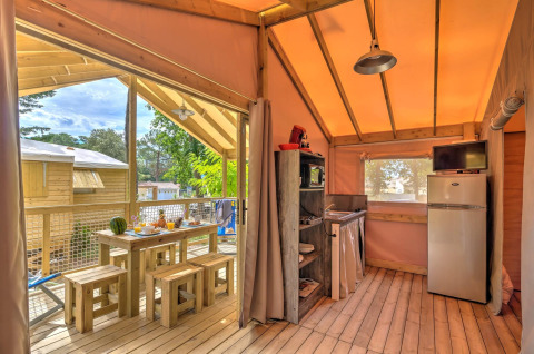 Interieurfoto van de boomhut Cosyflower met eethoek en keuken bij Flower Camping Au Bois Des Biches.