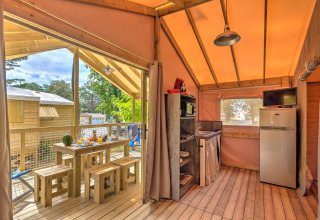 Interieurfoto van de boomhut Cosyflower met eethoek en keuken bij Flower Camping Au Bois Des Biches.