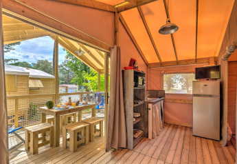 Indvendigt billede af træhuset Cosyflower med spiseplads og køkken på Flower Camping Au Bois Des Biches.