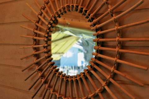 Miroir avec cadre en bois tressé dans la cabane Cosyflower, Flower Camping Au Bois Des Biches, France.