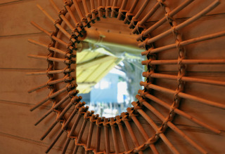 Miroir avec cadre en bois tressé dans la cabane Cosyflower, Flower Camping Au Bois Des Biches, France.