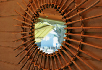 Specchio con cornice intrecciata in legno nella casa sull’albero Cosyflower, Flower Camping Au Bois Des Biches, Francia.
