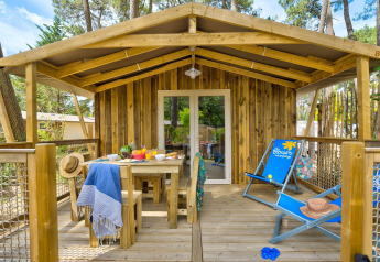 Terrazza in legno del lodge Sweetflower al Flower Camping Au Bois Des Biches in Francia tra i pini.