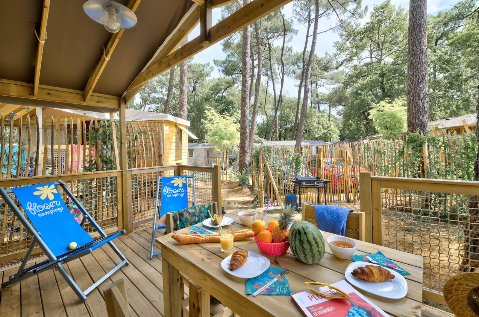 Houten terras bij Sweetflower-lodge, Flower Camping Au Bois Des Biches, met ontbijt en ligstoelen in Frankrijk.