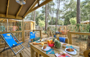 Houten terras bij Sweetflower-lodge, Flower Camping Au Bois Des Biches, met ontbijt en ligstoelen in Frankrijk.