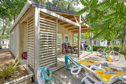 Veranda del Cottage Premium al Flower Camping Au Bois Des Biches con sdraio, bicicletta e giochi estivi.