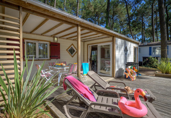 Udendørsområde ved Cottage Premium, Flower Camping Au Bois Des Biches, Frankrig med liggestole og flamingobadering.