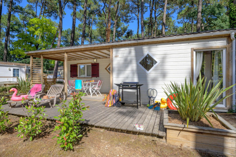 Veranda del Cottage Premium al Flower Camping Au Bois Des Biches, Francia, con giocattoli e sedie.