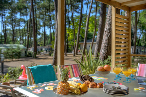 Tavolo all’aperto al Cottage Premium di Flower Camping Au Bois Des Biches, Francia, con frutta e succhi.