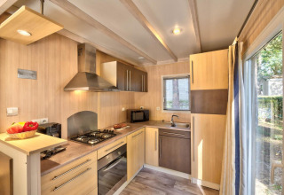 Cucina moderna nel Cottage Premium al Flower Camping Au Bois Des Biches, con ampie finestre e dettagli in legno.