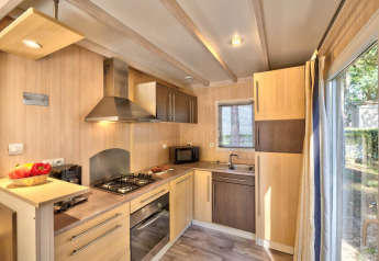 Moderne kabinekøkken i Cottage Premium på Flower Camping Au Bois Des Biches, med komfur og vindue.