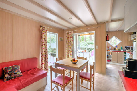 Luminoso soggiorno nel Cottage Premium al Flower Camping Au Bois Des Biches, Francia, con tavolo da pranzo.