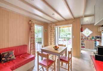 Lyst interiør i Cottage Premium, Flower Camping Au Bois Des Biches, med spisebord og røde møbler.