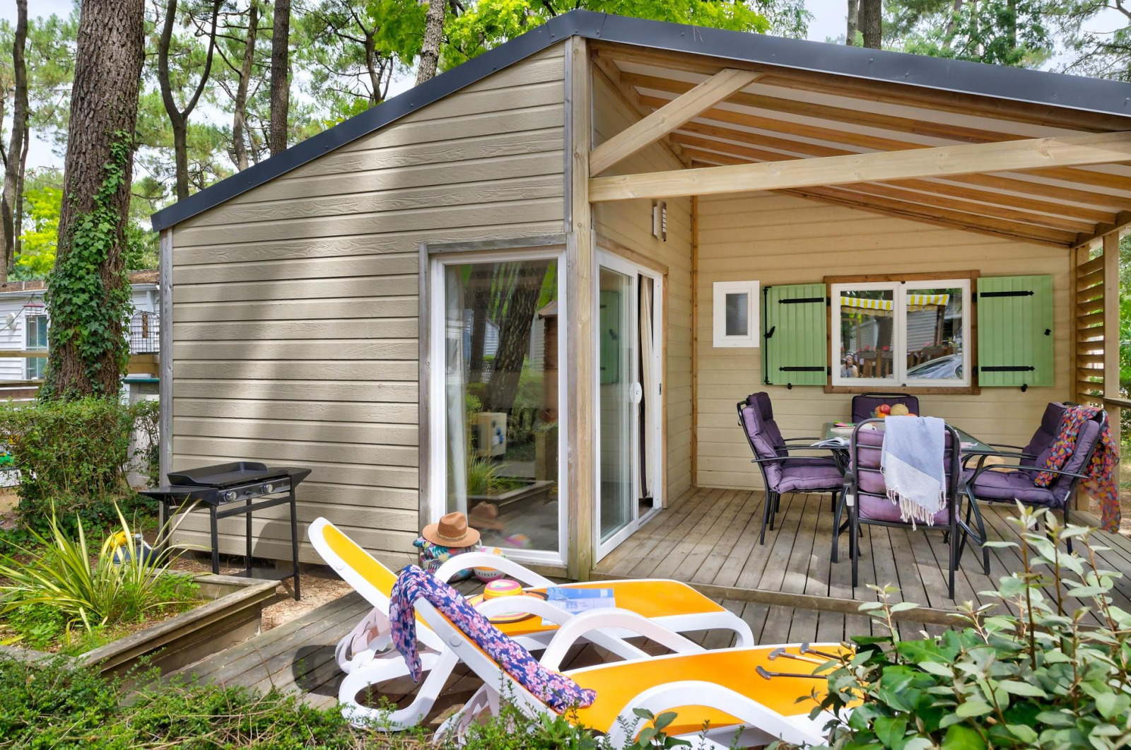 Cottage Premium bij Flower Camping Au Bois Des Biches in Frankrijk met terras, stoelen en ligbedden.