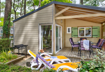 Cottage Premium al Flower Camping Au Bois Des Biches in Francia, con terrazza, sedie e lettini prendisole.