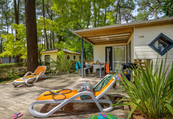 Terrazza soleggiata con lettini al Cottage Premium di Flower Camping Au Bois Des Biches, immersa nella natura.