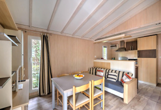 Stue og køkkenområde i Cottage Premium ved Flower Camping Au Bois Des Biches i Frankrig, lyst og hyggeligt.