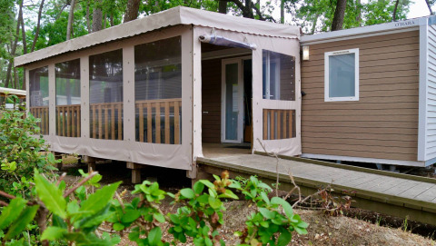 Chalet Stacaravan Life au Flower Camping Au Bois Des Biches en France avec terrasse couverte en pleine nature.