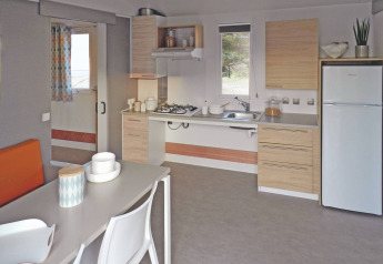 Moderne Küche und Essbereich in einem Stacaravan Life Chalet im Flower Camping Au Bois Des Biches, Frankreich.