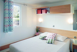 Modern chalet bedroom at Stacaravan Life, Flower Camping Au Bois Des Biches, France, with cozy decor.