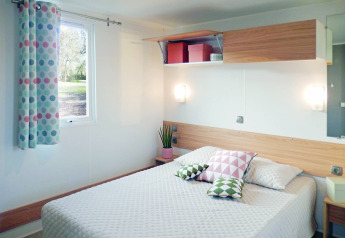 Modern chalet bedroom at Stacaravan Life, Flower Camping Au Bois Des Biches, France, with cozy decor.
