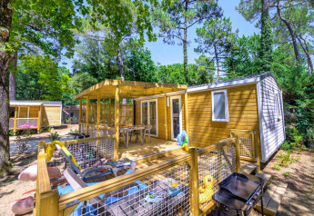 Vue extérieure du chalet Stacaravan Family au Flower Camping Au Bois Des Biches, entouré d’arbres verdoyants.