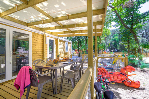 Houten terras van Stacaravan Family op Flower Camping Au Bois Des Biches met zicht op speeltuin in Frankrijk.