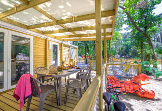 Houten terras van Stacaravan Family op Flower Camping Au Bois Des Biches met zicht op speeltuin in Frankrijk.