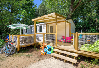Vista esterna di Stacaravan Family con terrazza in legno e biciclette al Flower Camping Au Bois Des Biches, Francia.