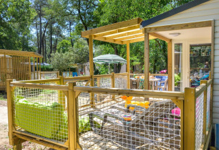 Terrazza esterna di uno chalet con spiedini alla griglia, immersa nel verde bosco in Francia.