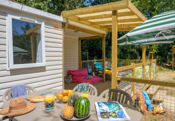 Patio esterno allo Stacaravan Family del Flower Camping Au Bois Des Biches, Francia, con frutta e sedute relax.