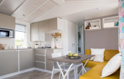 Cuisine et salle à manger modernes et lumineuses du chalet Stacaravan Family au Flower Camping Au Bois Des Biches, France.