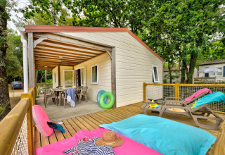 Buitenterras van Cottage Family bij Flower Camping Au Bois Des Biches, Frankrijk, met ligstoelen en tafel.
