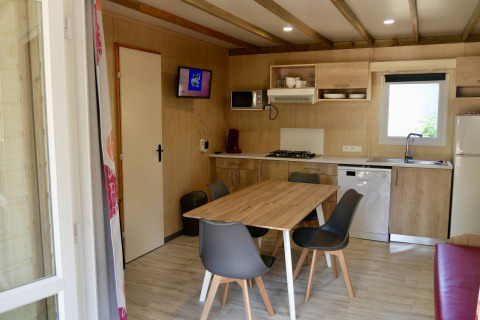 Moderne keuken en eetplaats in Cottage Family chalet bij Flower Camping Au Bois Des Biches, Frankrijk.