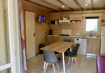 Moderne køkken og spiseområde i Cottage Family, Flower Camping Au Bois Des Biches, med træinteriør.