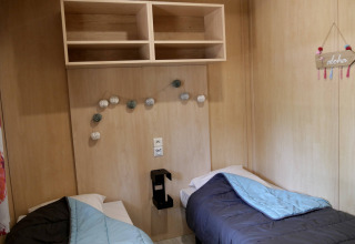 Twee enkele bedden in een knusse houten chaletkamer van Cottage Family, Flower Camping Au Bois Des Biches in Frankrijk.