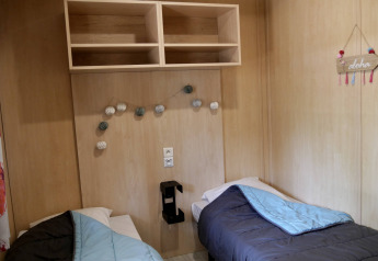 Deux lits simples dans une chambre de chalet en bois au Cottage Family, Flower Camping Au Bois Des Biches en France.