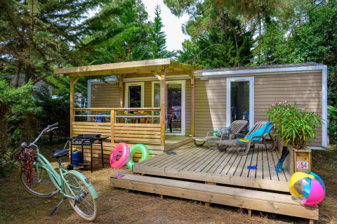 Buitenaanzicht van Stacaravan Premium+ chalet bij Flower Camping Au Bois Des Biches met terras en vakantieartikelen.