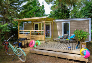 Buitenaanzicht van Stacaravan Premium+ chalet bij Flower Camping Au Bois Des Biches met terras en vakantieartikelen.