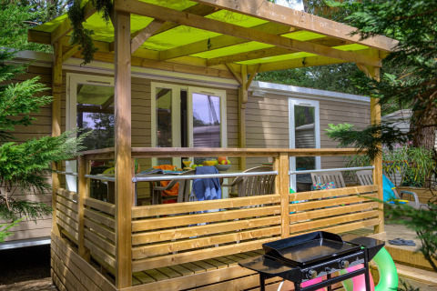 Houten terras met barbecue aan Stacaravan Premium+ bij Flower Camping Au Bois Des Biches in Frankrijk.