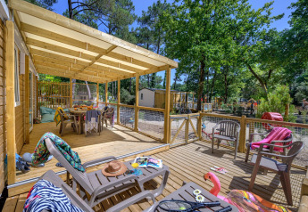 Überdachte Holzterrasse mit Gartenmöbeln bei Stacaravan Family im Flower Camping Au Bois Des Biches, Frankreich.