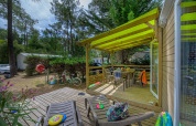 Terrasse der Stacaravan Premium+ im Flower Camping Au Bois Des Biches, Frankreich, mit Spielzeug und Möbeln.