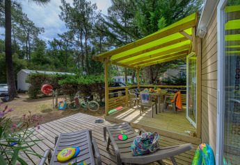Terrasse der Stacaravan Premium+ im Flower Camping Au Bois Des Biches, Frankreich, mit Spielzeug und Möbeln.