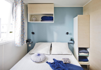 Chambre lumineuse et compacte d'un chalet Stacaravan Family au Flower Camping Au Bois Des Biches, France.